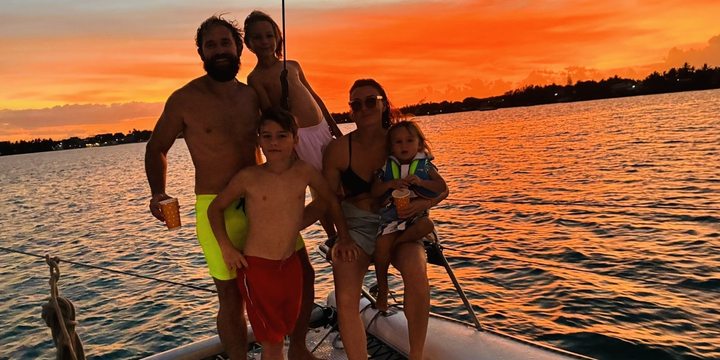 The whole family on a catamaran at sunset